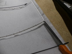 (Image: Cutting the white fabric tubing to allow insertion of the support rods)