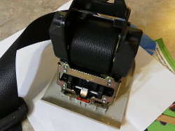 (Image: Closeup of rear seatbelt mechanism showing ad-hoc repair of cover plate)