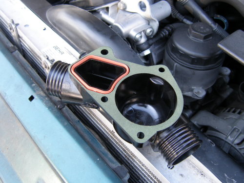 (Image: Closeup of flange of BMW plastic thermostat housing with profile 
	    gasket installed