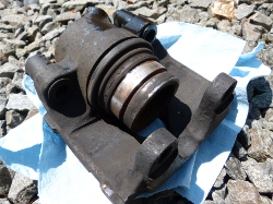 (Image: Old front caliper with piston popped out)