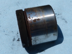 (Image: Old front caliper piston closeup showing rust)