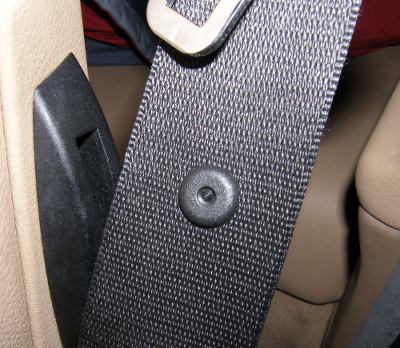 (Image: Closeup of seatbelt retainer button installed with BMW special tool)