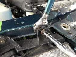 (Image: Using wrench and ratchet to remove screw from adjuster)