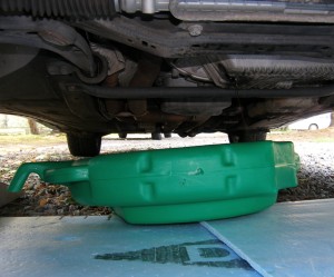(Image: Oil draining into basin under 
		    vehicle)