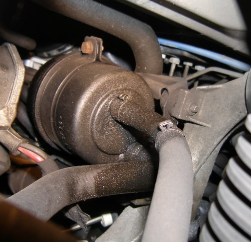 (Image: Bottom of power steering reservoir showing hoses leaking)