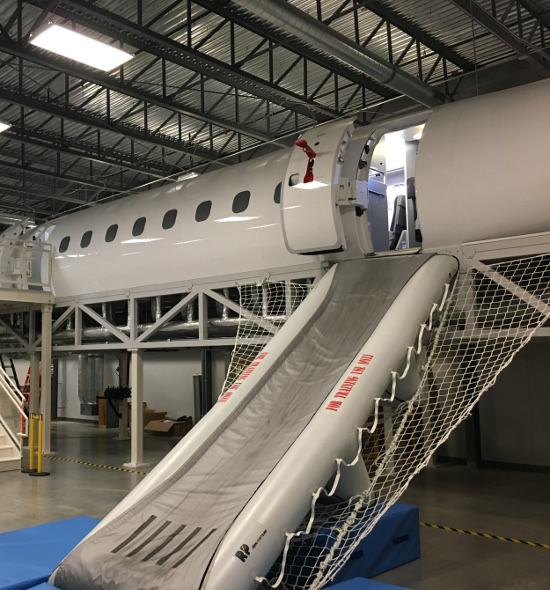 (Image: Emergency escape slide deployed on EMB175 training fuselage)