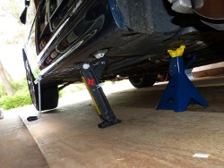 (Image: Looking toward rear of car with jack and jack stand in foreground)